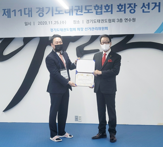 25일 수원시 팔달구 경기도태권도협회 3층 GTA연수원에서 열린 제11대 경기도태권도협회장 선거에서 당선된 김경덕 후보자(오른쪽)가 서영조 선거관리위원회 위원장으로부터 당선증을 교부받고 있다. (사진=경기도태권도협회 제공)