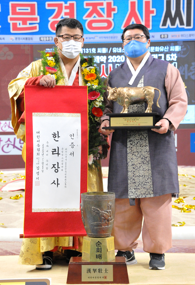 29일 경북 문경시 문경실내체육관에서 열린 위더스제약 2020 민속씨름리그 5차 문경장사씨름대회에서 한라장사(105㎏급)에 등극한 우형원(용인백옥쌀)이 장덕제 감독과 장사인증서와 황소트로피를 들고 기념사진을 찍고 있다. (사진=대한씨름협회 제공)