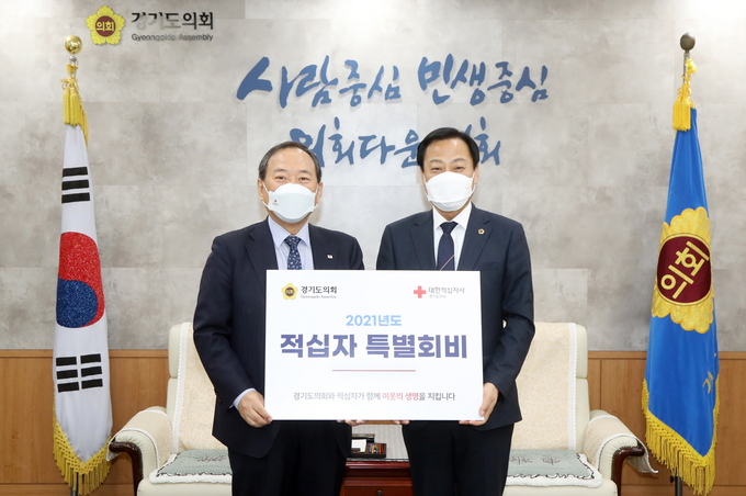 경기도의회 장현국 의장(오른쪽)과 윤신일 대한적십자사 경기도지사 회장(왼쪽)이 기념촬영을 하고 있다(사진=경기도의회 제공)