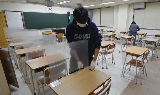  수원시 장안구 장안고등학교에서 관계자들이 수험생들의 코로나19 감염 예방을 위해 시험장에 책상 가림막을 설치하고 있다. (사진=황준선 기자)