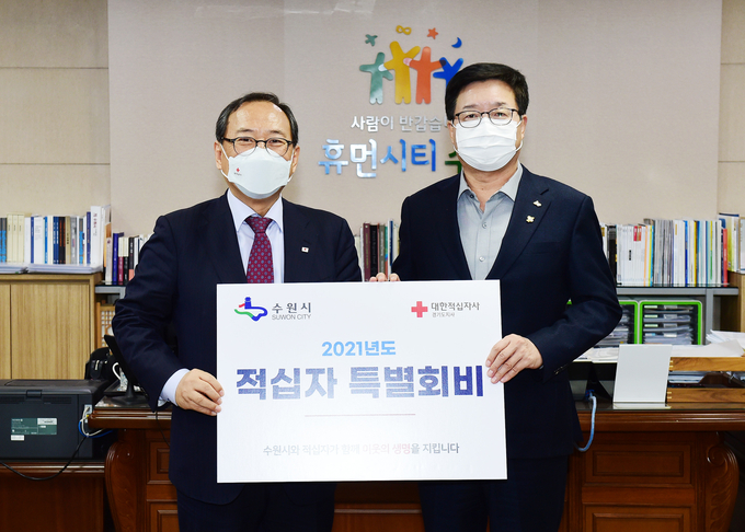 염태영 시장(오른쪽)과 윤신일 대한적십자사 경기도지사 회장이 전달식 후 기념촬영을 하고 있다. (사진=수원시청 제공)