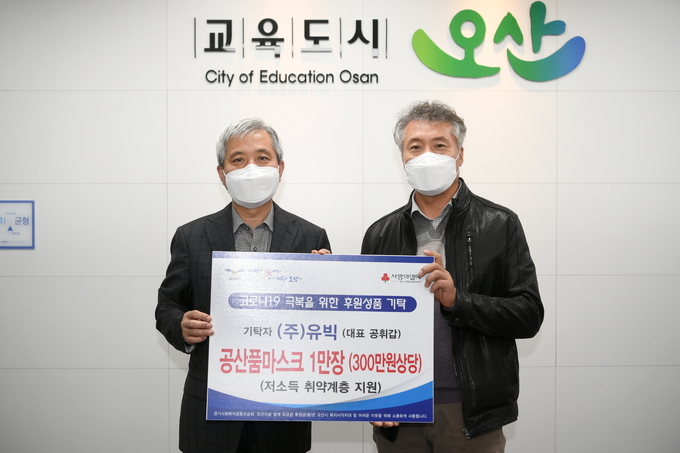 ㈜유빅이 시청을 찾아 관내 저소득층을 위해 사용해 달라며 마스크 1만매를 기탁해 이용진 ㈜유빅 부사장과 곽상욱 오산시장이 기념촬영을 하고 있다. (사진=오산시 제공)