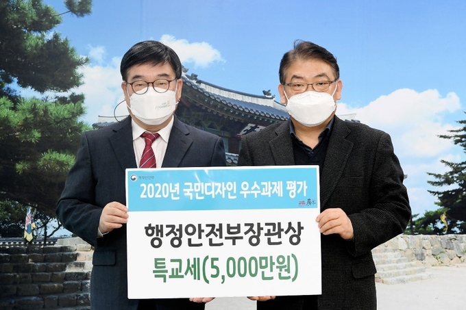 광주시가 행정안부가주관하는 2020년 국민디자인단 성과 평가에서 행정안전부 장관상을 수상해 신동헌시장과 조종호 기획 예산담당관이 부상으로 특교세 5천만원을 수여하고 있다. (사진=광주시 제공)