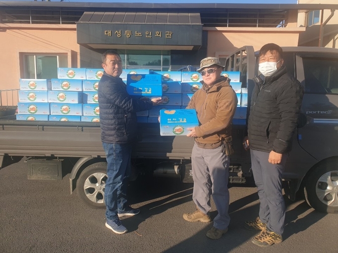 같은 마을이름이 인연이 돼 자매결연을 맺은 파주 대성동 주민들이 제주도 대성동에서 보내온 귤을 내리고 있다. (사진=파주시 제공)
