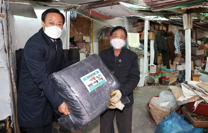 경기도의회 장현국 의장이 차상위계층 가구를 방문해 이불을 전달하고 있다(사진=경기도의회 제공)