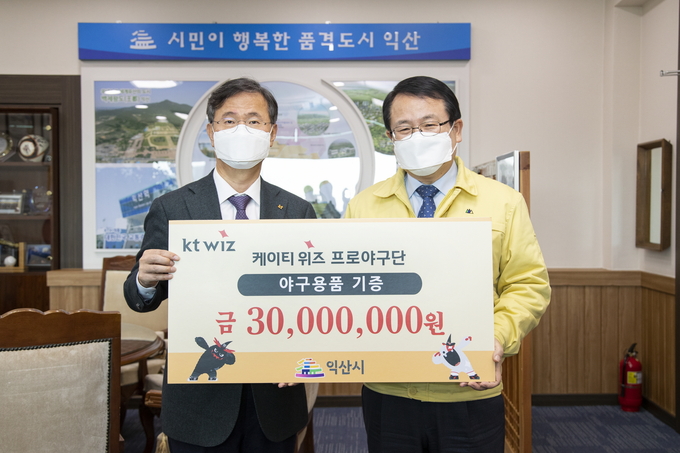 9일 오전 11시 전북 익산시청에서 열린 ‘사랑의 선물 꾸러미’ 나눔 행사에서 남상봉 kt 스포츠 사장(왼쪽)이 정헌율 익산시장에게 야구용품을 전달한 뒤 기념촬영을 하고 있다. (사진=kt 위즈 제공)
