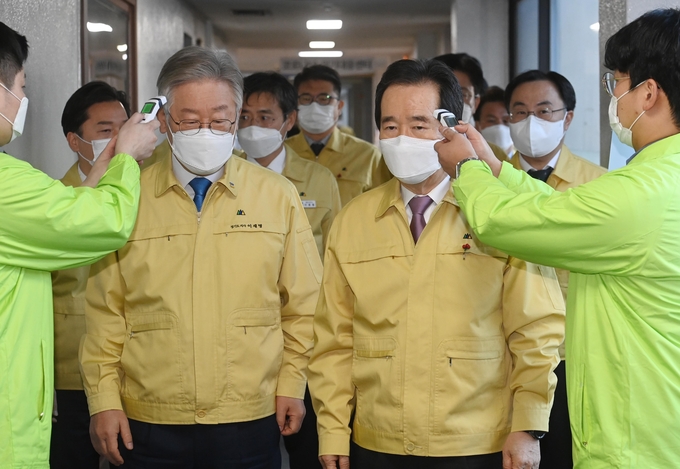 9일 오전 정세균 국무총리가 이재명 경기도지사와 코로나 바이러스 감염증 19 중앙재난안전대책본부 회의종료 후 홈케어시스템 운영단을 방문하면서 체온을 재고 있다. (경기사진공동취재단)