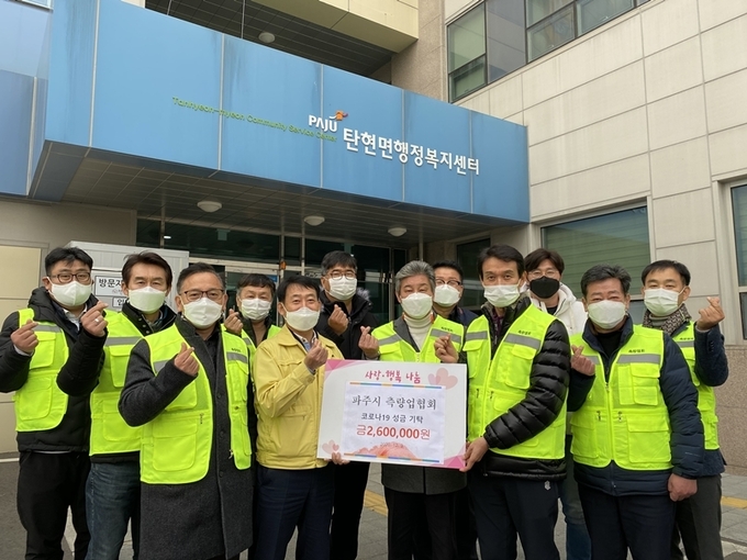 파주시측량업협회 회원들이 탄현면에 성금을 전달하고 있다. (사진=파주시 제공)