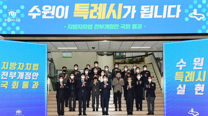 지난 10일 오전 수원시청 로비에서 지방자치법 전부개정안 통과를 축하하며 염태영 수원시장과 수원시 직원들이 기념촬영을 하고 있다. (사진=수원시 제공)
