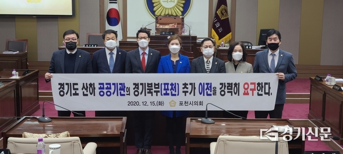 본회의가 끝난 후 포천시의회 의원들이 공공기관 경기북부 이전 촉구 현수막을 들고 기념촬영하고 있다. (사진=문석완 기자)