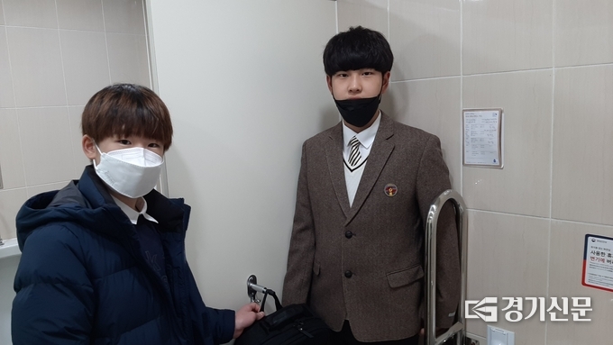 '화장실 낮은 옷걸이 정책'을 제안한 김태윤·전성재 학생이 청소년 교육 문화 센터 화장실에 설치된 낮은 옷걸이에 가방을 걸어보이고 있다. (사진=포천시 제공)