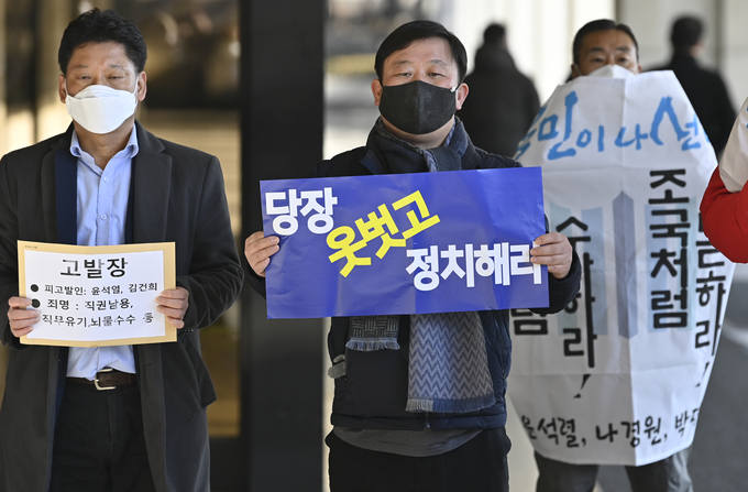 안진걸 민생경제연구소 소장이 17일 오전 서울중앙지검 앞에서 '당장 옷 벗고 정치해라'라는 손 피켓을 들고 서 있다. 이날 민생경제연구소 등 11개 시민단체는 윤석열 검찰총장을 직무유기와 직권남용, 뇌물수수 등의 혐의로 서울중앙지검에 고발했다. (사진=황준선 기자) 