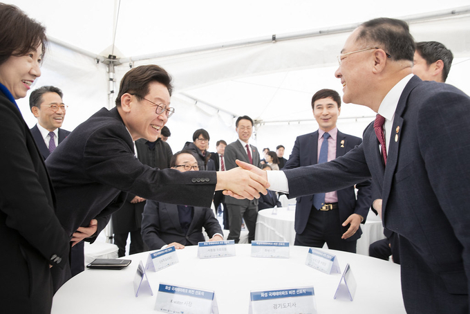 이재명 경기도지사(왼쪽)와 홍남기 경제부총리가 악수를 하고 있다. (사진= 경기도 제공)