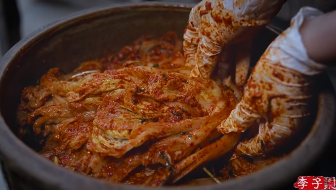 리쯔치가 배추에 양념을 묻히고 있다. (사진=리쯔치 유튜브 화면 캡처)
