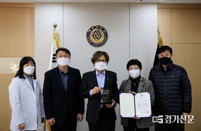 아주대 의대 김영선 연구강사(왼쪽)와 정선용 의대 교수, 박형주 총장, 김경민 의대 교수, 오기환 시설팀 계장이 기념 사진을 촬영하고 있다.