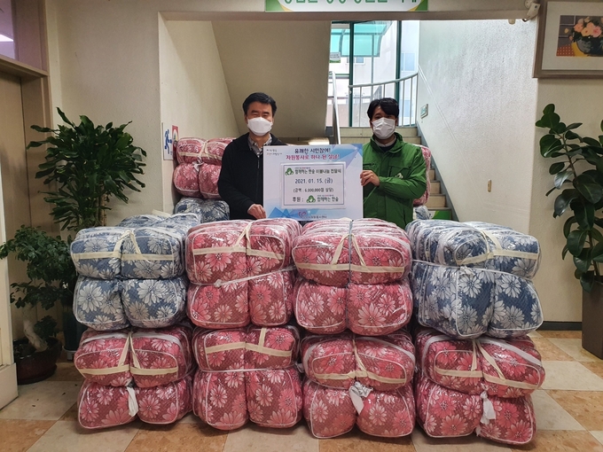 한숲 권훈상대표(우측)가 성남시자원봉사센터 이덕은 센터장에게 이불을 전달하고 있다.(사진=성남시자원봉사센터 제공)