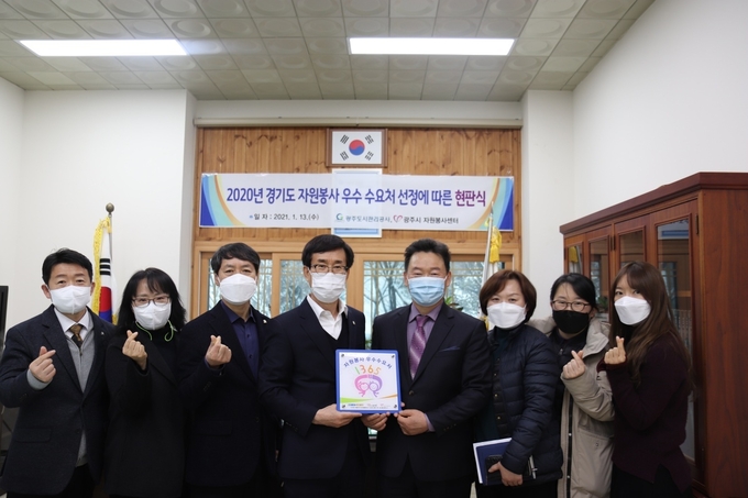 이한범 (사) 광주시자원봉사센터장은 '2020년 경기도 우수수요처'로 선정된 광주도시관리공사를 방문해 유승하 사장등 직원들이 참석한 가운데 현판을 전달하고 있다. (사진=광주시자원봉사센터 제공)