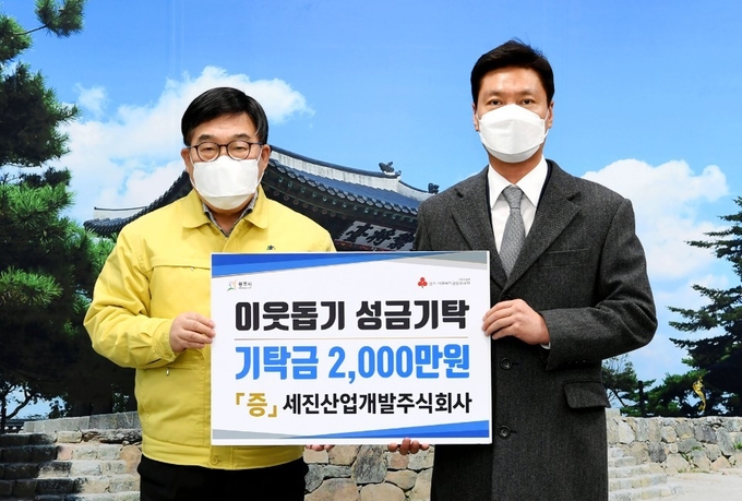 최문석 세진산업개발대표가 신동헌 광주시장에게 어려운 이웃을 위해 써 달라며 성금 2천만원을 기탁하고 있다. (사진=광주시 제공)