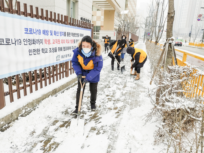 사진은 화성 동탄 신도시의 한 학교 앞 인도에 쌓인 눈을 치우는 하나님의 교회 신자들의 모습 (사진=하나님의 교회 제공)