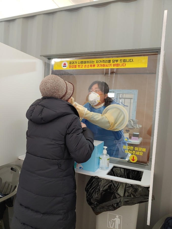 도내 한 선별검사소에서 의료봉사 중인 도교육청 소속 한 보건교사가 검사자로부터 검체를 채취하고 있다. (사진=경기도교육청 제공)