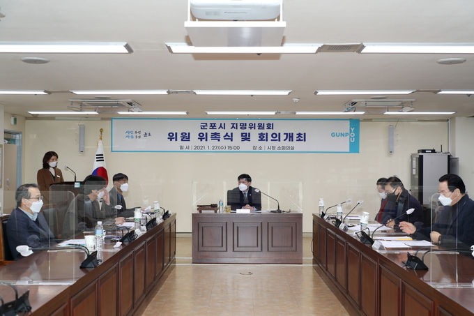 한대희 시장(가운데) 주재로 열린 군포시 지명위원회에서 신설되는 동 명칭에 관해 논의하고 있다.