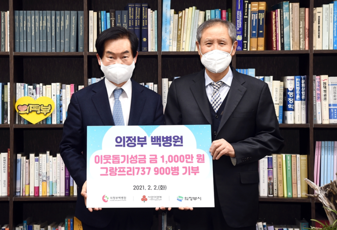 우영섭 백병원 이사장(우측)이 안병용 의정부시장에게 성금품을 전달하고 있다.