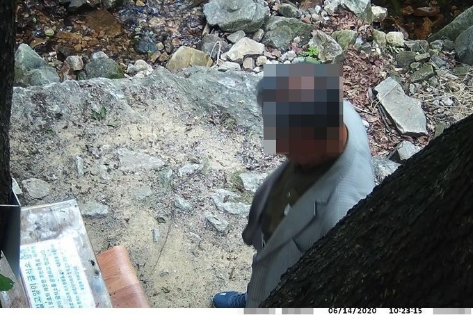 지난해 6월 경기 동두천시 소요산에 설치된 '길고양이 급식소'에서 사료를 갖다버리는 범행을 저지른 70대 남성이 폐쇄회로(CC)TV에 포착된 모습. (사진=신춘숙씨 제공/연합뉴스)