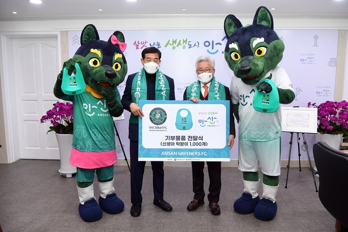 안산그리너스FC가 사회공헌활동으로 안산시 신생아를 위해 턱받이 1000개를 기부했다. 사진은 윤화섭 안산시장(왼쪽)과 김호석 대표이사(오른쪽)가 기념촬영하고 있는 모습 (사진=안산그리너스FC 제공) 