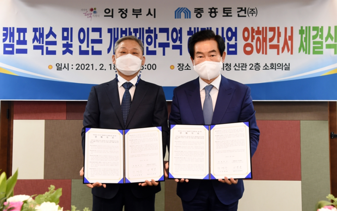 안병용 의정부시장(오른쪽)이 지난 18일 이경호 중흥토건 대표와 캠프잭슨 및 인근지역의 개발제한구역 해제사업 추진을 위한 양해각서를 체결한 뒤 기념촬영을 하고 있다. (사진=의정부시 제공)