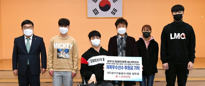 ㈜경기기술공사 심민섭 대표가 광주지역 체육유망 선수장애인 체육선수 한만현, 정선정, 강성모, 정희철 등 4명에게 후원금 1200만원을 전달하고 있다. (사진=광주시 제공)