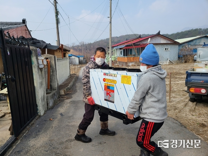 청학회 회원들이 교체할 새 보일러를 옮기고 있다. (사진=포천시종합자원봉사센터 제공)
