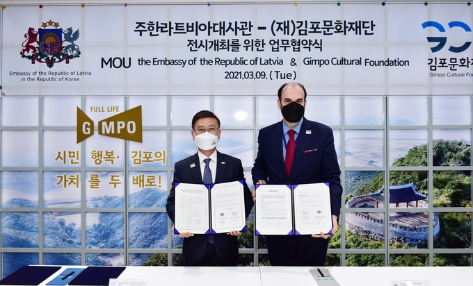 김포문화재단 정하영 이사장(왼쪽)과 주한라트비아 대사가 문화교류 전시회 개최 업무협약을 체결하고 기념사진을 찍고 있다. (사진=김포문화재단 제공)