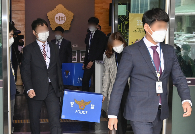 경찰이 시흥시의원의 3기 신도시 투기 의혹 관련 수사를 벌이고 있는 15일 시흥시 연성동 시흥시의회에서 의원 사무실 압수색을 마친 경찰 관계자들이 압수품을 가지고 나서고 있다. (사진=경기신문 황준선 기자)