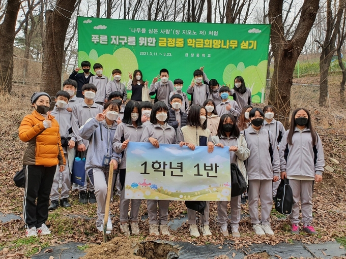 군포 금정중 1학년 학생들이 ‘푸른 지구를 위한 학급 희망나무 심기’ 행사에서 기념촬영을 하고 있다.