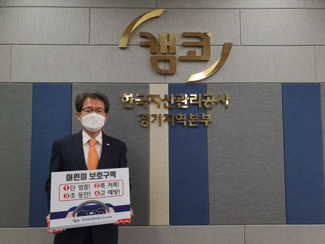 양기영 캠코 경기지역본부장이 어린이 교통안전 표어를 들고 사진촬영을 하는 모습. (사진=한국자산관리공사(캠코))