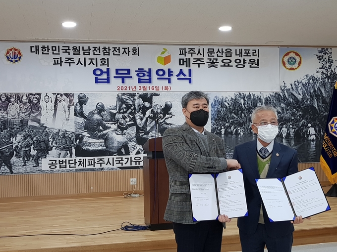파주월남참전자회 김동준 지회장(사진 오른쪽)과 이성훈 메주꽃 시설장이 업무협약서를 들어보이고 있다. (사진=최연식 기자)