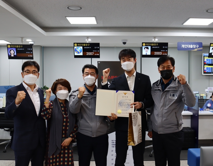 안양 만안경찰서가 보이스피싱을 예방한 신한은행 안양 금융센터 직원에게 감사장과 보상금을 전달하고 있다.