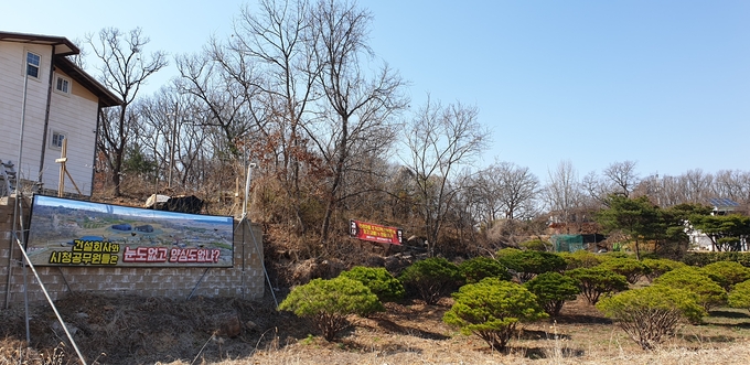 제조장 건설이 예정된 예술인 마을 내 부지. 현재 부지에는 건축주와 시를 비난하는 현수막이 걸려있다. (사진=천용남 기자)