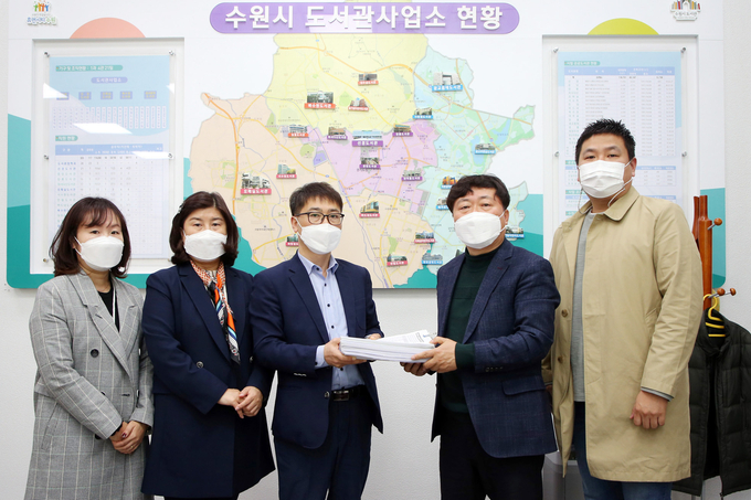 수원시의회 조미옥 의원(왼쪽 두번째)이 지난 23일 수원시 도서관사업소 관계자에게 '권선구 금곡동 지역 공공도서관 건립'을 촉구하는 주민 서명부를 전달하고 있다. (사진=수원시의회 제공)