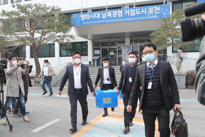 포천시청에 대한 압수수색을 마친 경찰이 확보한 자료를 들고 나오고 있다. (사진=연합뉴스 제공)