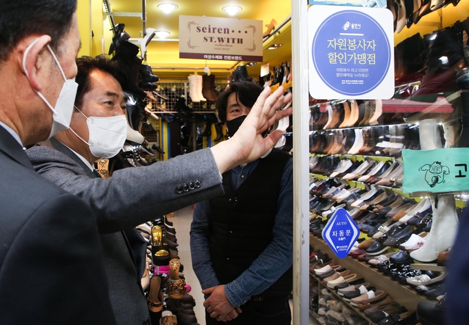 백군기 용인시장이 24일 용인중앙시장 내에 있는 자원봉사자 할인가맹점을 둘러보고 있다. (사진=용인시 제공)