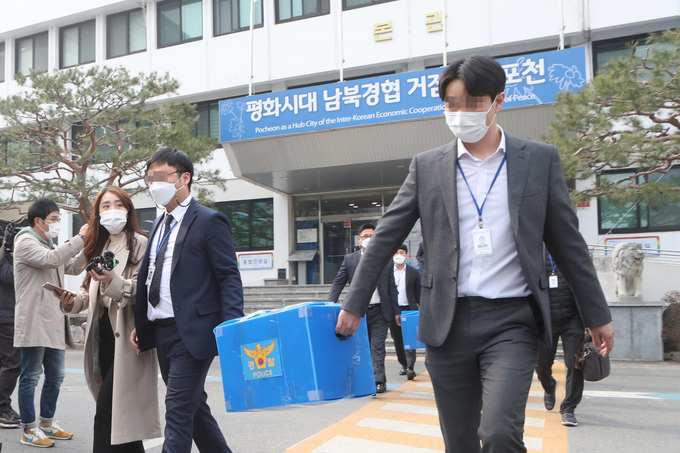 포천시청에 대한 압수수색을 마친 경찰이 확보한 자료를 들고 나오고 있다. (사진=연합뉴스 제공)
