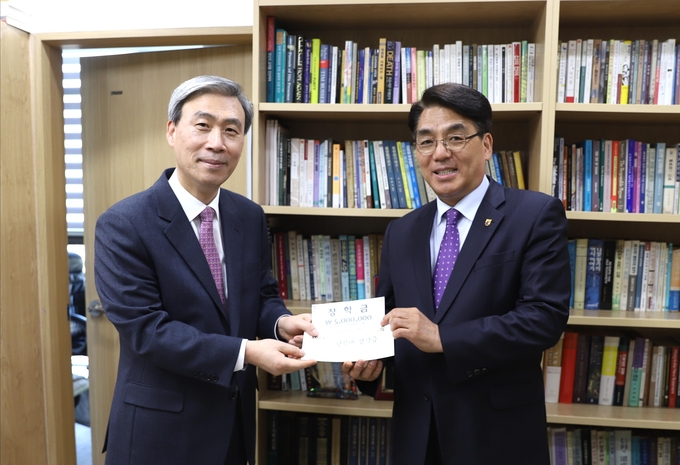 서귀포중앙교회 이상호 목사가 한신학원 박상규 이사장에게 장학금을 전달하는 모습. (사진=한신대학교 제공)