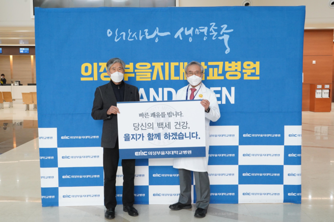윤병우 원장이 첫 외래환자 박모씨를 맞는 이벤트를 하고 있다.