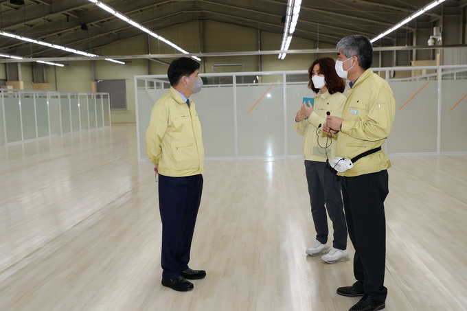한대희 시장(왼쪽)이 백신접종센터 설치공사가 진행중인 시민체육광장 체육관에서 관계자들로부터 설명을 듣고 있다.