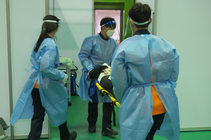 광명소방서가는 광명시 예방접종센터 모의훈련에서 백신접종 후 이상 반응 환자를 응급처치를 하기 위해 옮기는 훈련을 하고 있다. (사진=광명소방서 제공)