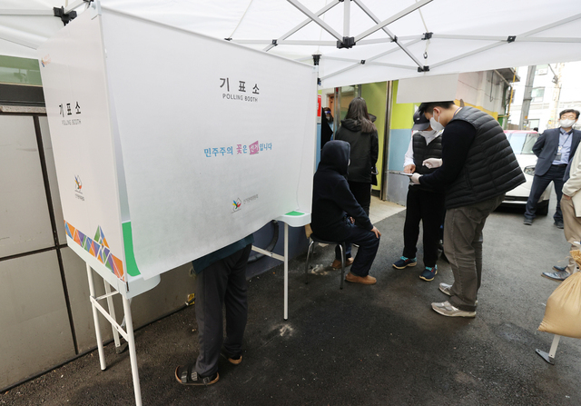  4·7 재보궐선거 사전투표 첫날인 2일 오전 서울 중구 소공동주민센터에 마련된 사전투표소에서 투표소가 설치된 4층까지 계단으로 오르기 힘든 한 유권자가 임시기표소에서 기표하고 있다. (사진=연합뉴스) 