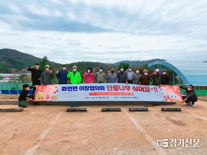 화현면 이장협의회 회원들이 단풍나무 식수기념 포스터를 들어보이고 있다. (사진=포천시 제공)