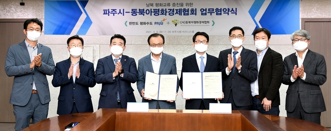파주시와 동북아평화경제협회가 업무협약을 체결, 최종환 파주시장과 이해찬 협회 이사장이 협약서를 들어보이고 있다. (사진=파주시 제공)