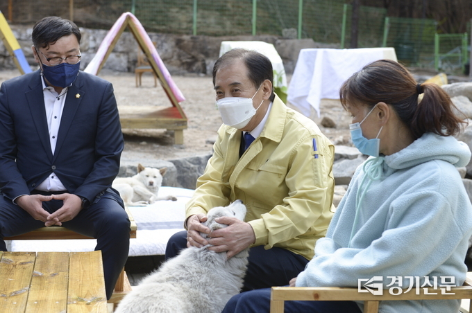 보호소에서 보호 중인 강아지 한 마리가 애교를 부리자 박윤국 시장이 환하게 웃고 있다. (사진=포천시 제공)